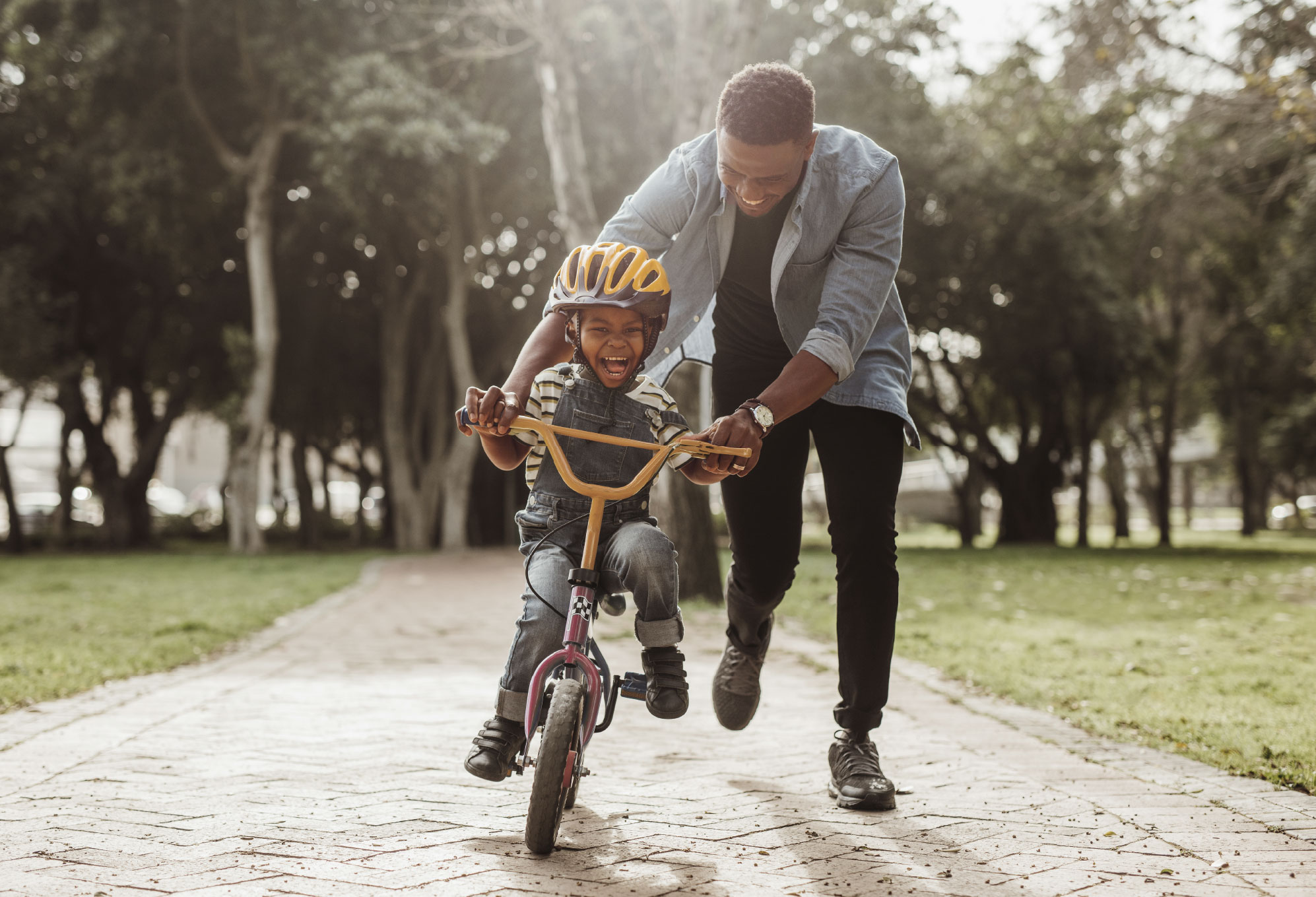 Dad teaching boy to ride a bike