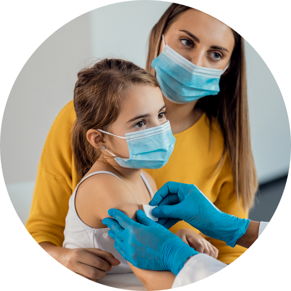 Image of a child and parent both wearing masks as the child gets a vaccine